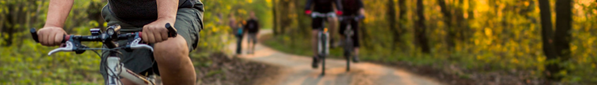 Senior man riding his bike on a wooded trail on a crisp fall afternoon