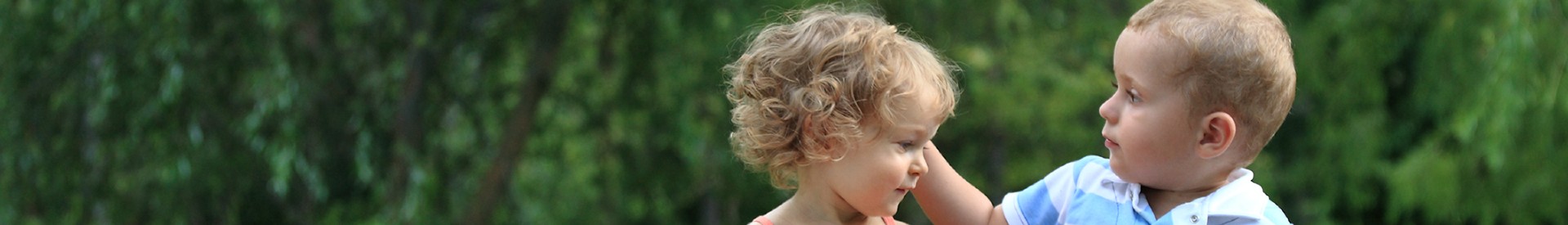 Young boy playing with sister's hair