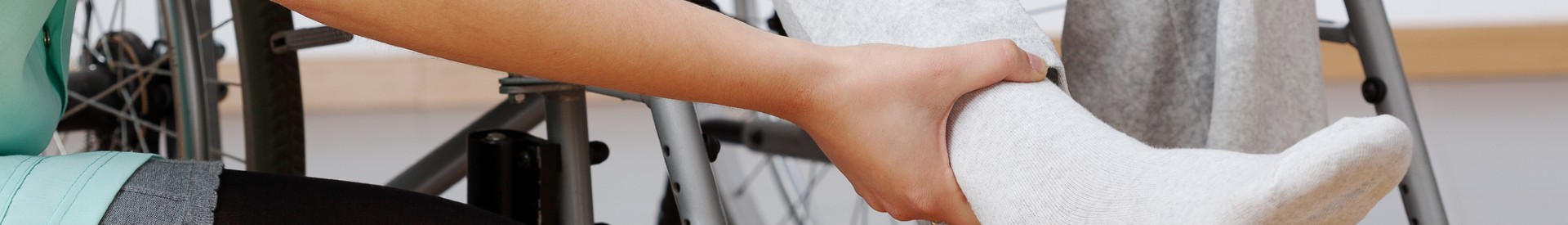 Patient in wheelchair holding ankle