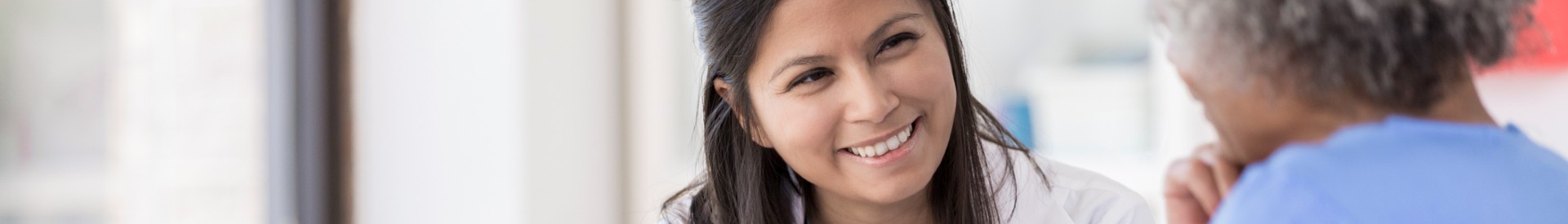 Smiling doctor listens to patient