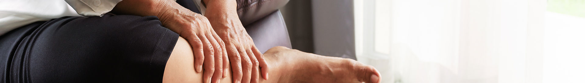 Patient with edema sitting holding calf