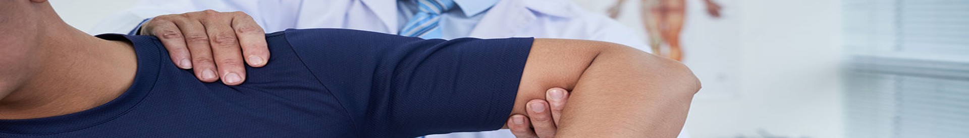 Orthopedic doctor examines man's shoulder