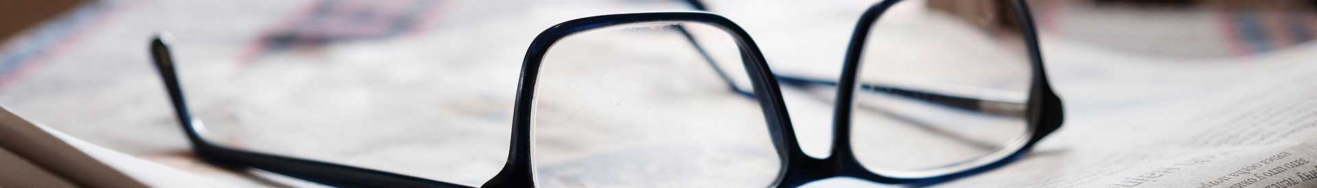 reading glasses laying on a newspaper